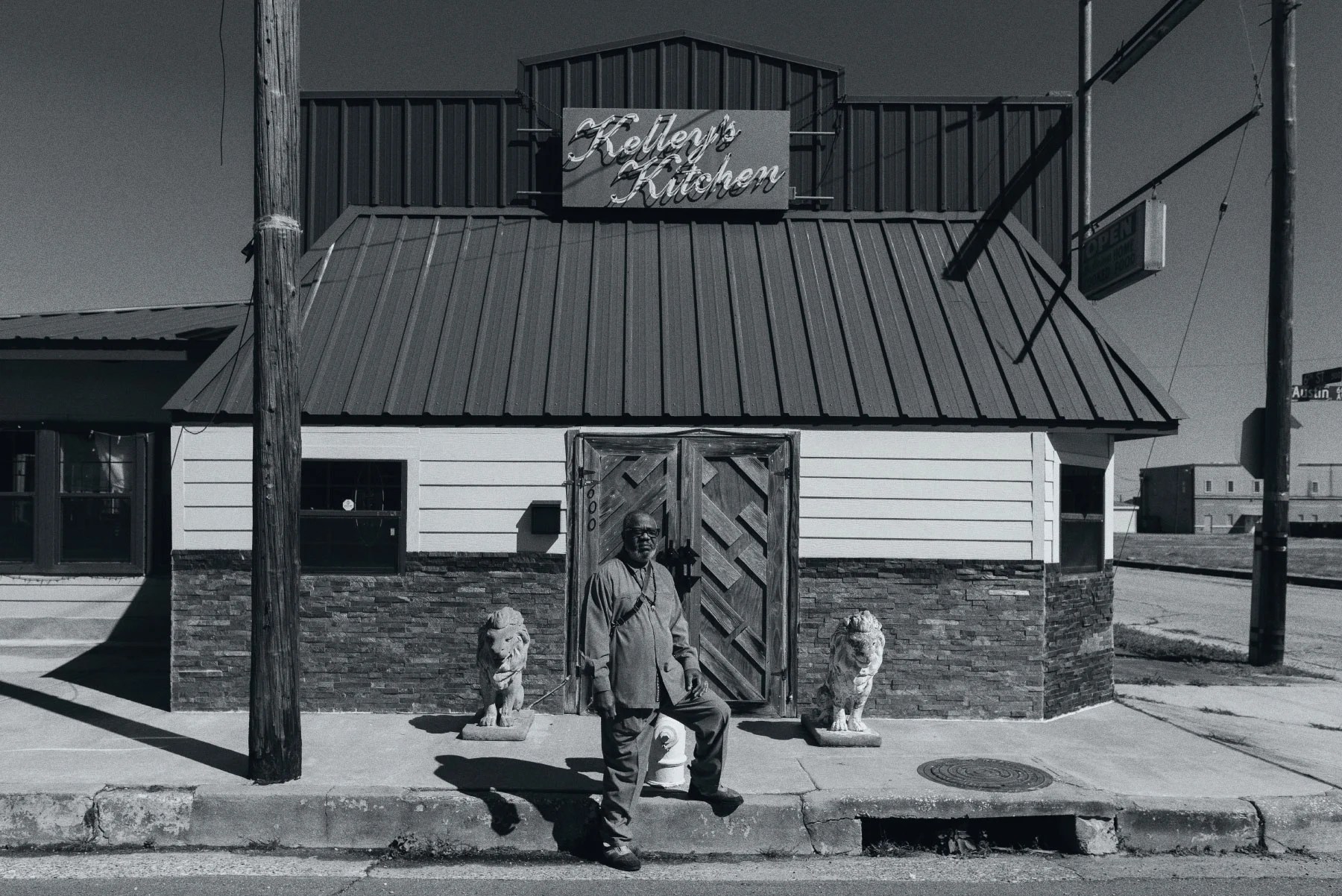 man stands in front of restaurant