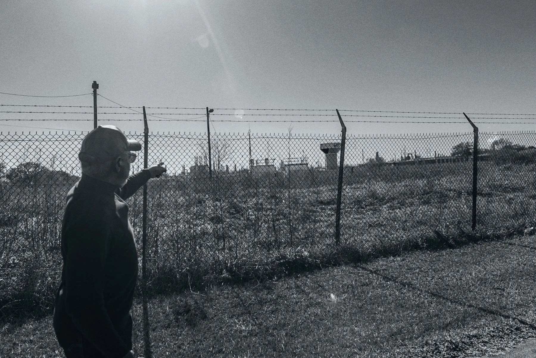 man points across field at an air monitor