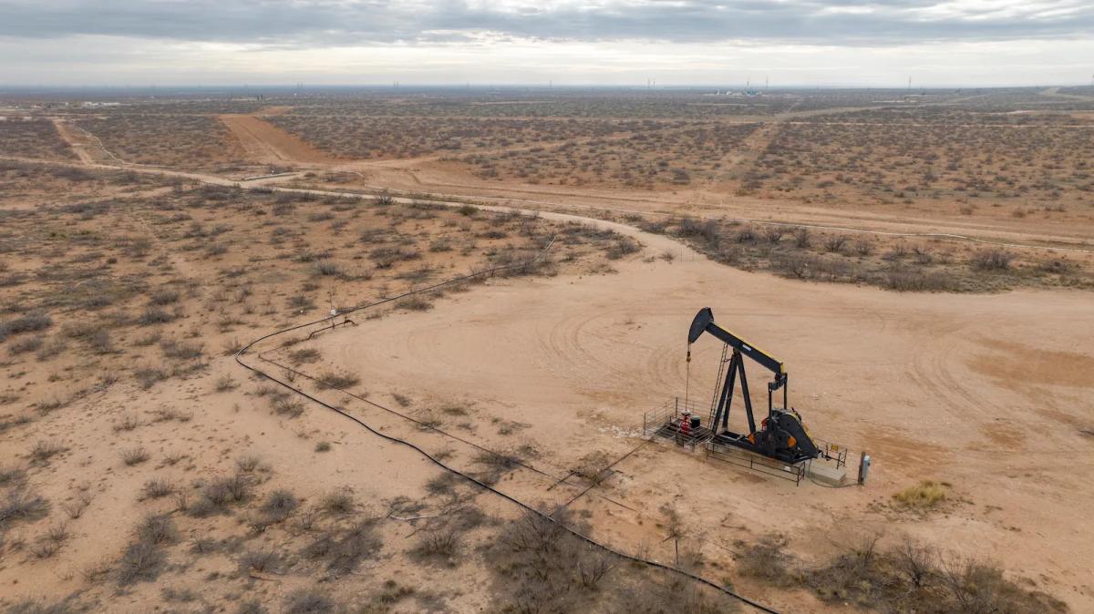 a pumpjack on a large parcel of desert land