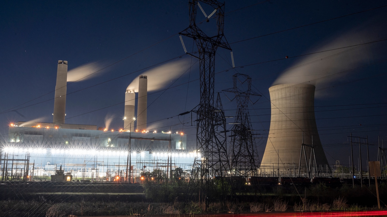 Steam rises from the smokestacks to fill the night sky above the Miller coal Power Plant in Adamsville, Alabama.